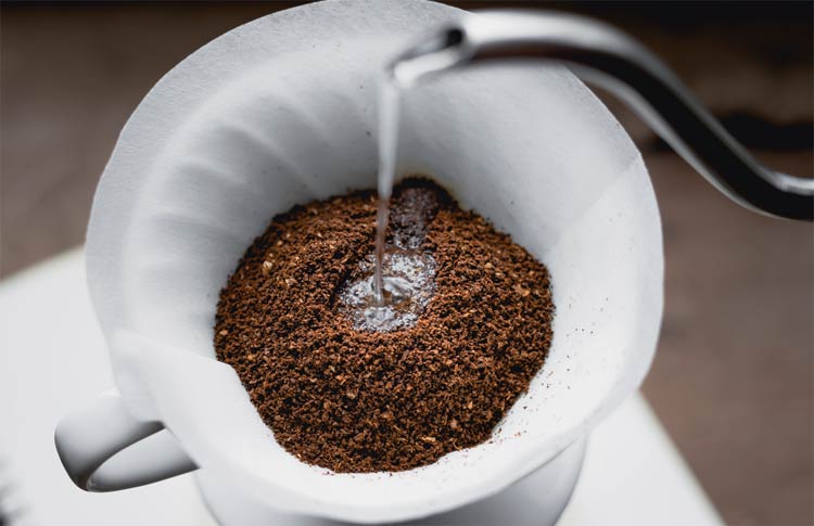 wasser-wird-auf-kaffee-in-porzellanfilter-gegossen